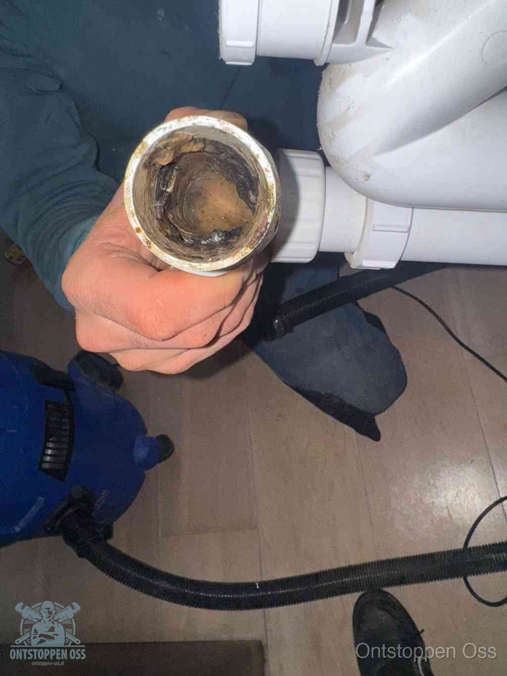 Een losgekoppeld afvoerbuisstuk dat van binnen volledig is dichtgeslibd, het gevolg van een verstopping te lang laten zitten in Oss