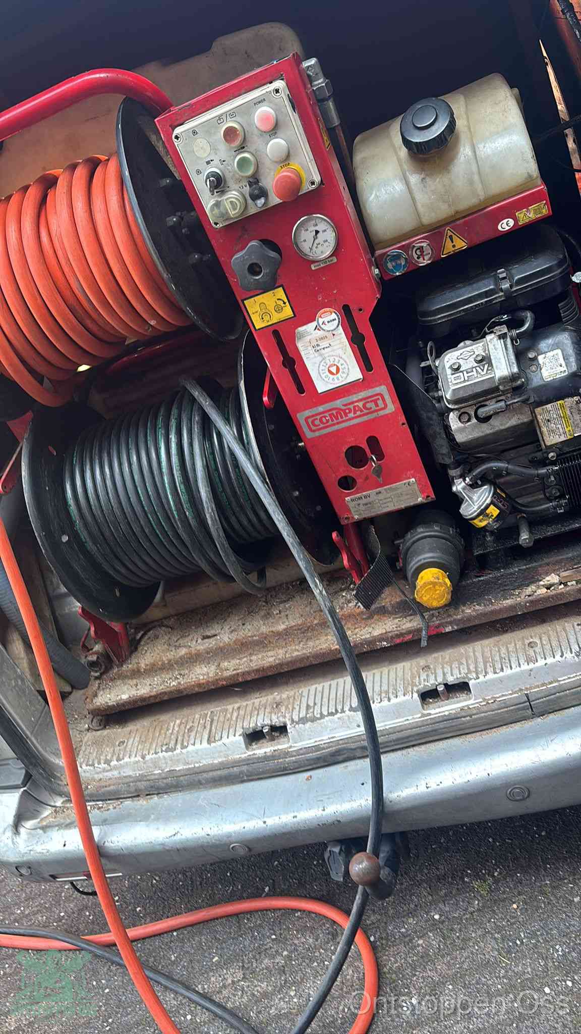 Een rood hogedruk-rioolreinigingstoestel in de laadbak van de bedrijfsbus, apparatuur voor een hardnekkige afvoerverstopping in Oss