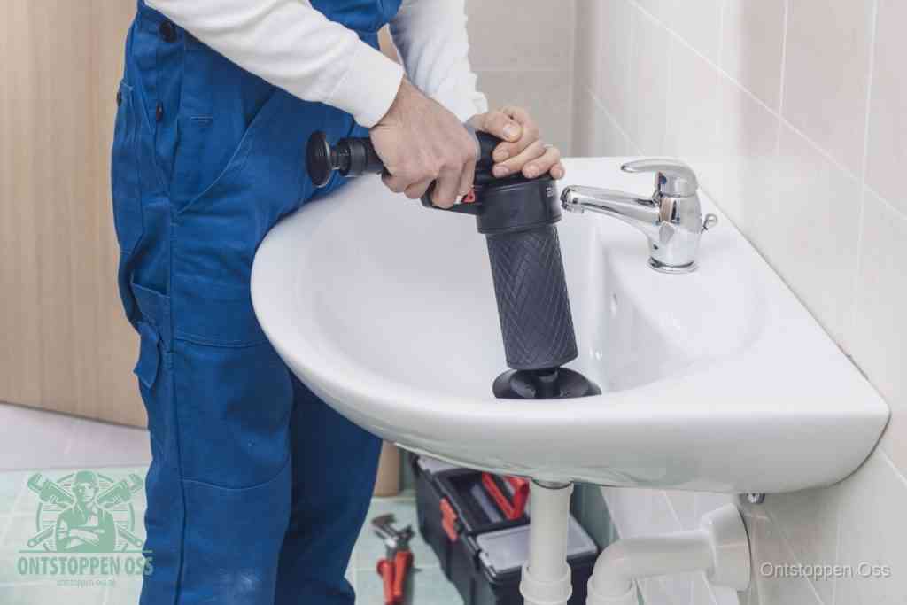 Een te ruwe doe-het-zelf poging met een hand-pomp op de afvoer van een badkamer-wastafel, een van de veelgemaakte fouten bij afvoer ontstoppen in Oss